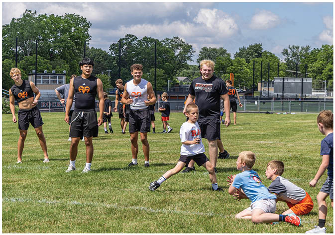 A group of football players wearing black and white uniforms. Description generated by AI