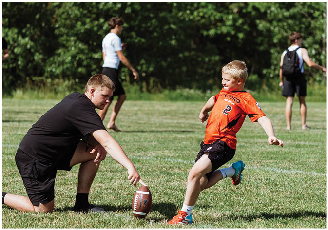A group of football players wearing black and white uniforms. Description generated by AI