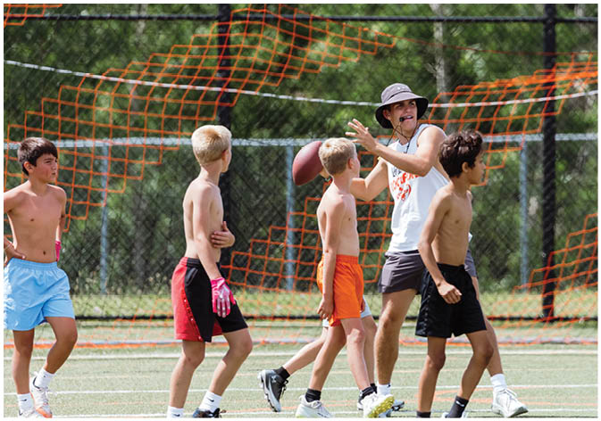 A group of football players wearing black and white uniforms. Description generated by AI