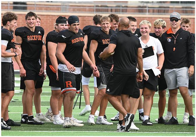A group of football players wearing black and white uniforms. Description generated by AI