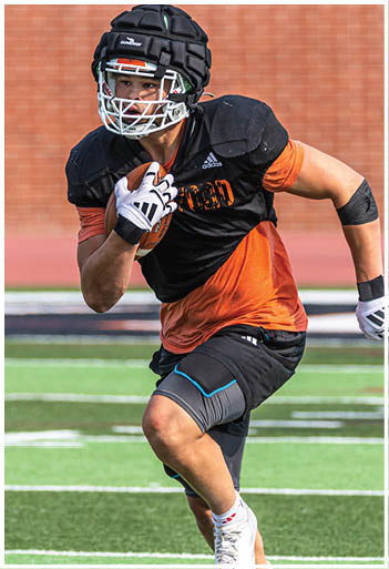 A football player running on the field. Description generated by AI