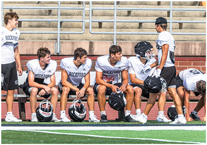 A group of football players wearing black and white uniforms. Description generated by AI
