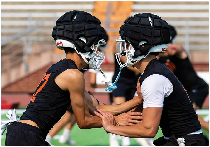 A group of football players wearing black and white uniforms. Description generated by AI