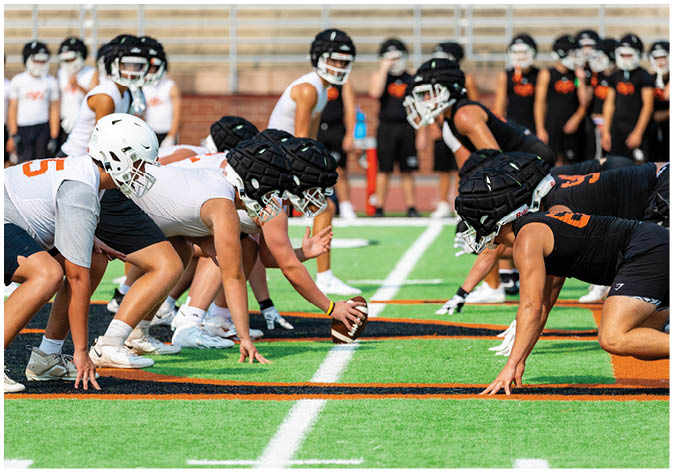 A group of football players wearing black and white uniforms. Description generated by AI