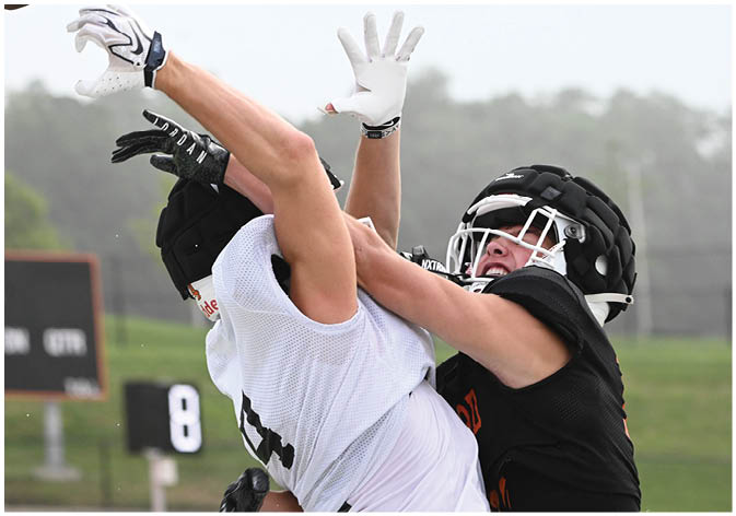 A group of football players wearing black and white uniforms. Description generated by AI