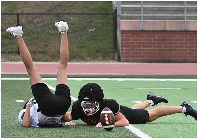 A group of football players wearing black and white uniforms. Description generated by AI