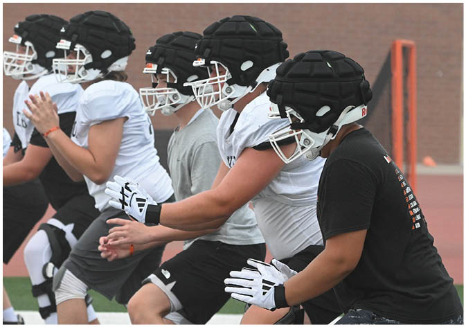 A group of football players wearing black and white uniforms. Description generated by AI