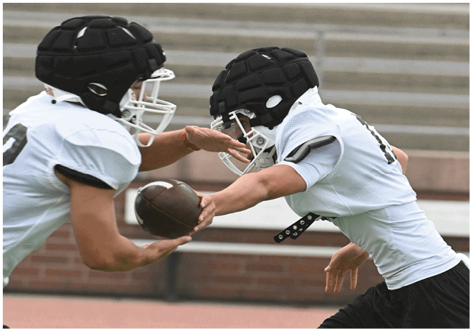 A group of football players wearing black and white uniforms. Description generated by AI