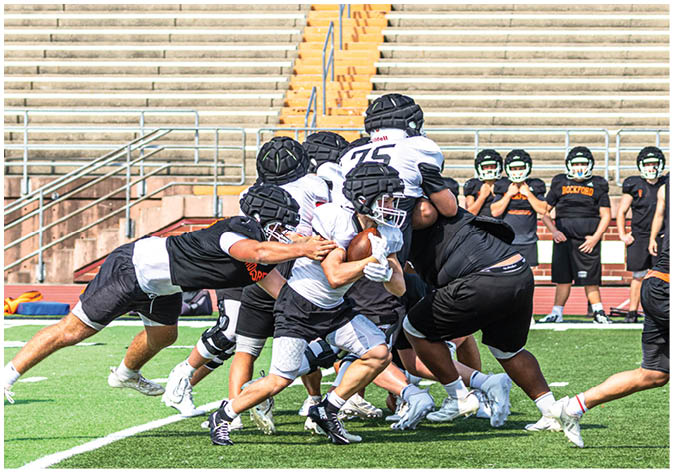 A group of football players wearing black and white uniforms. Description generated by AI