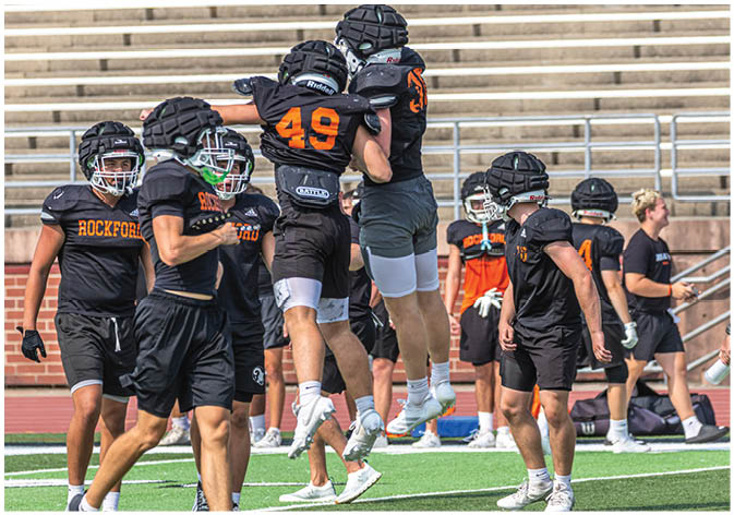 A group of football players wearing black and white uniforms. Description generated by AI