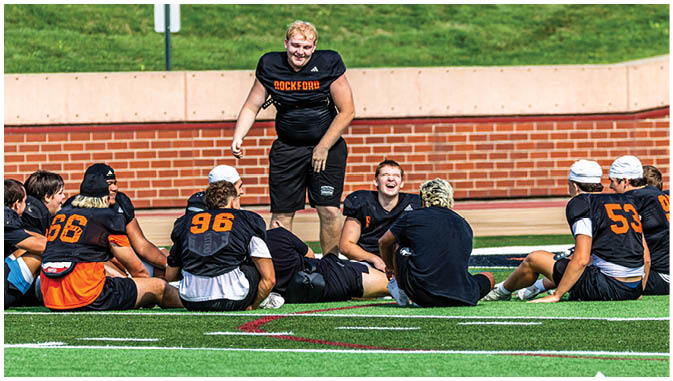 A group of football players on a field. Description generated by AI
