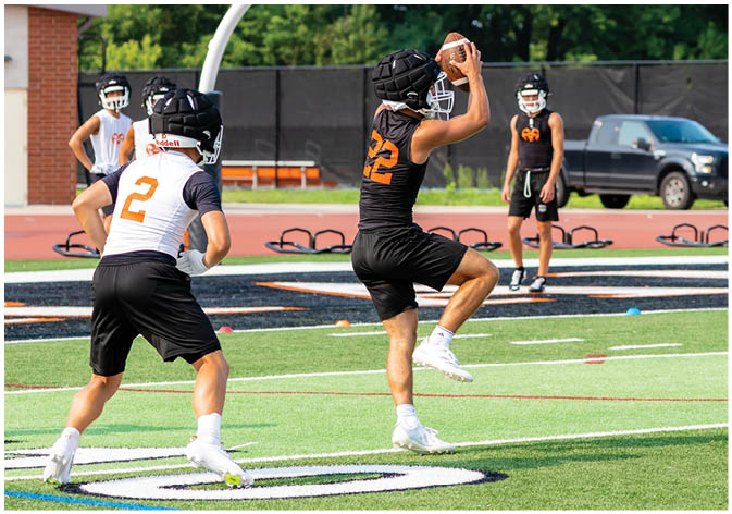 A group of football players wearing black and white uniforms. Description generated by AI