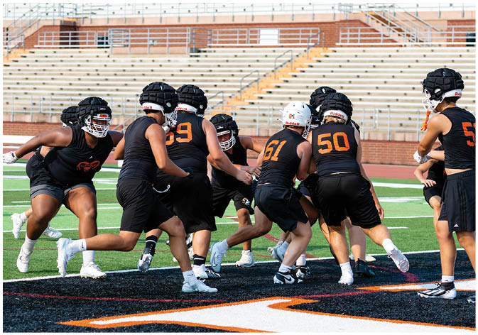 A group of football players wearing black and white uniforms. Description generated by AI