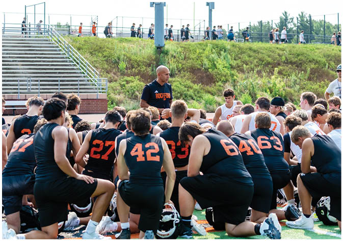 A group of football players wearing black and white uniforms. Description generated by AI