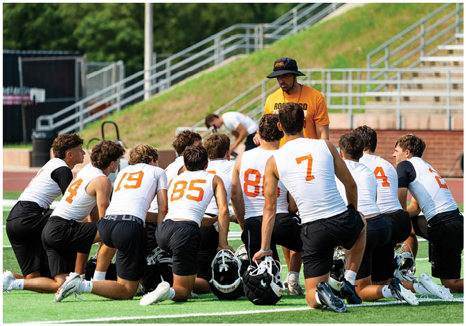 A group of football players wearing black and white uniforms. Description generated by AI