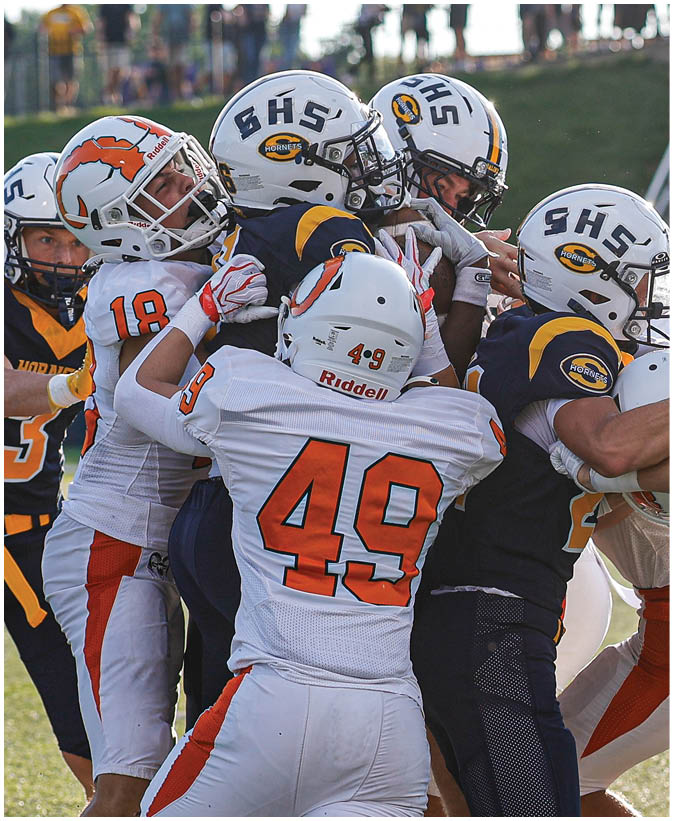 A group of football players on a field. Description generated by AI