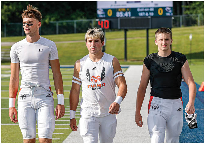 A group of football players wearing black and white uniforms. Description generated by AI