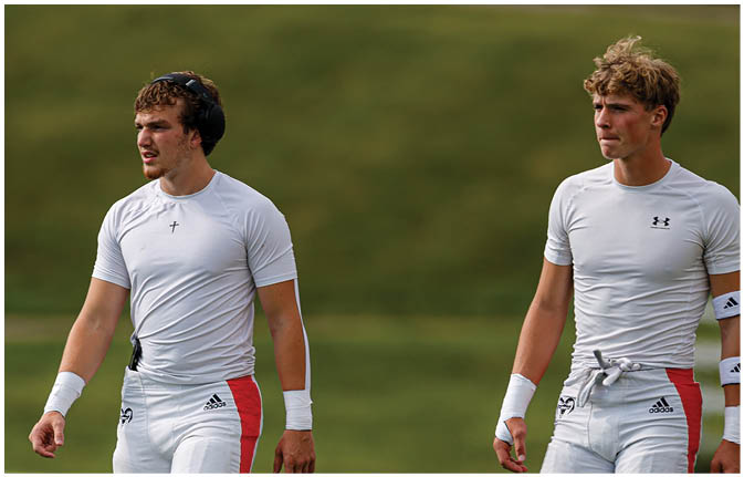 A group of football players wearing black and white uniforms. Description generated by AI