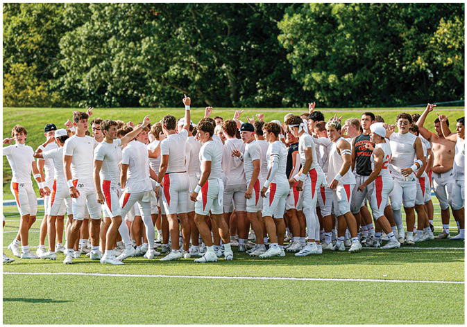 A group of football players wearing black and white uniforms. Description generated by AI