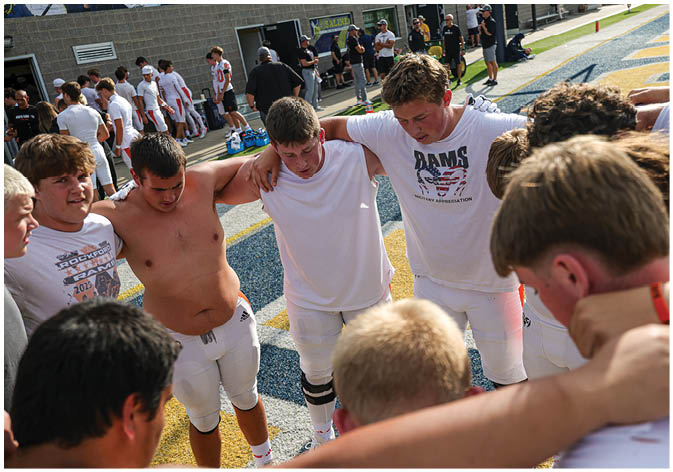 A group of football players wearing black and white uniforms. Description generated by AI