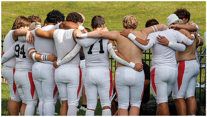 A group of football players on a field. Description generated by AI