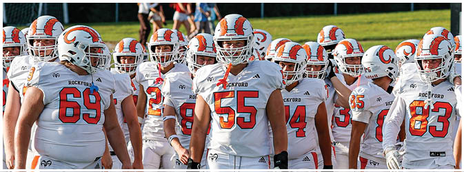 A football game is taking place on a field with players wearing blue and white uniforms. Description generated by AI