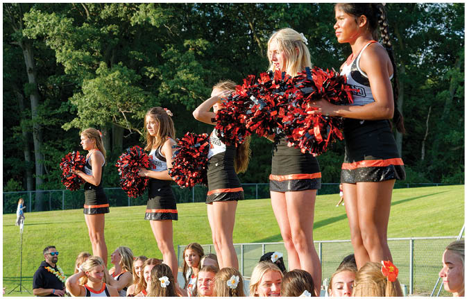 A group of football players wearing black and white uniforms. Description generated by AI