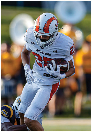 A football player wearing a blue and red jersey. Description generated by AI