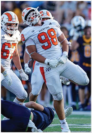 A football player wearing a blue and red jersey. Description generated by AI