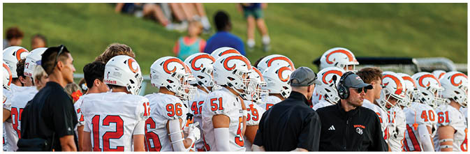 A group of football players on a field. Description generated by AI