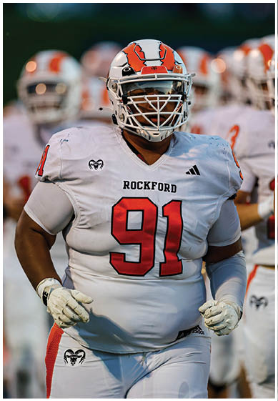 A football player wearing a blue and red jersey. Description generated by AI