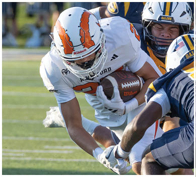 A football game is taking place with a group of men on the field. Description generated by AI