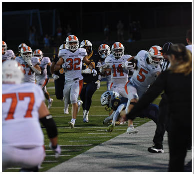A football game is taking place with a group of men on the field. Description generated by AI