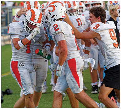 A football game is taking place with a group of men on the field. Description generated by AI