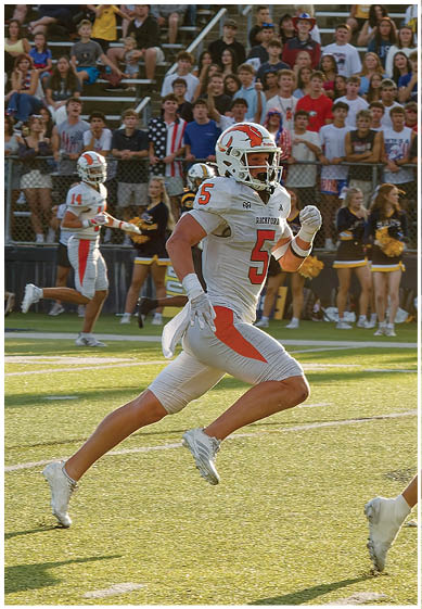 A football player wearing a blue and red jersey. Description generated by AI