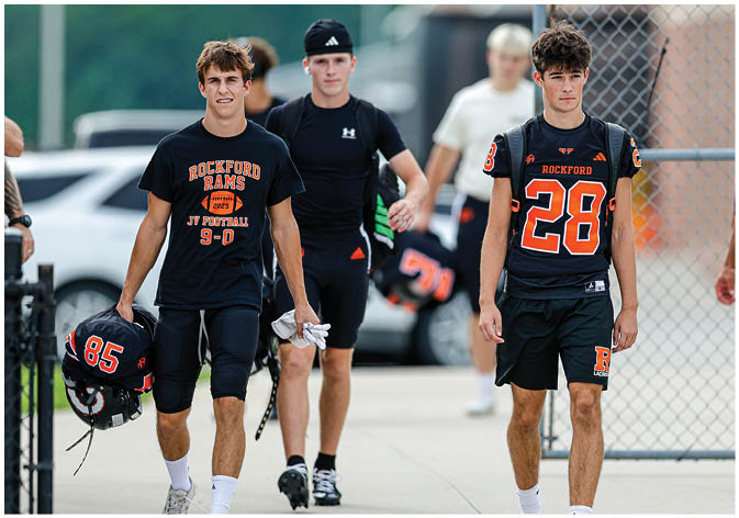A group of football players wearing black and white uniforms. Description generated by AI