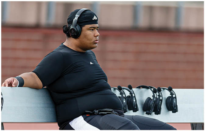 A group of football players wearing black and white uniforms. Description generated by AI