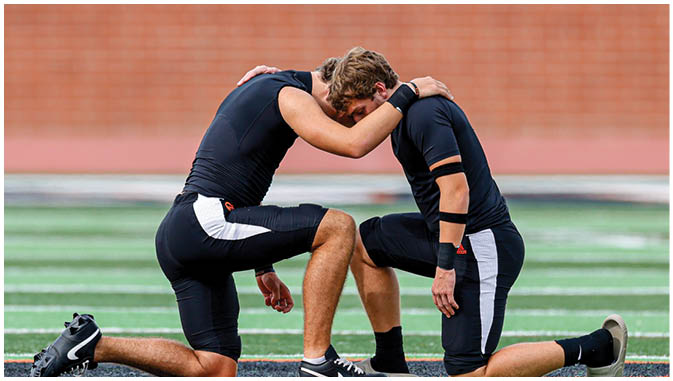 A group of football players on a field. Description generated by AI