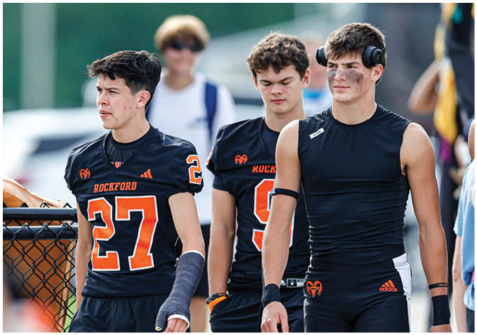 A group of football players wearing black and white uniforms. Description generated by AI