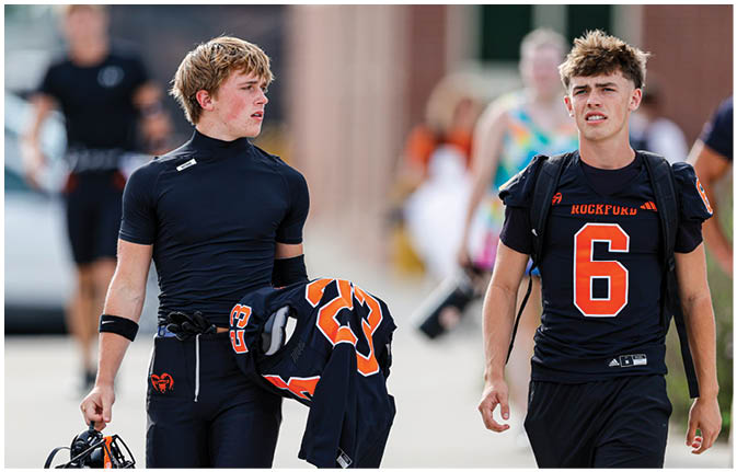 A group of football players wearing black and white uniforms. Description generated by AI
