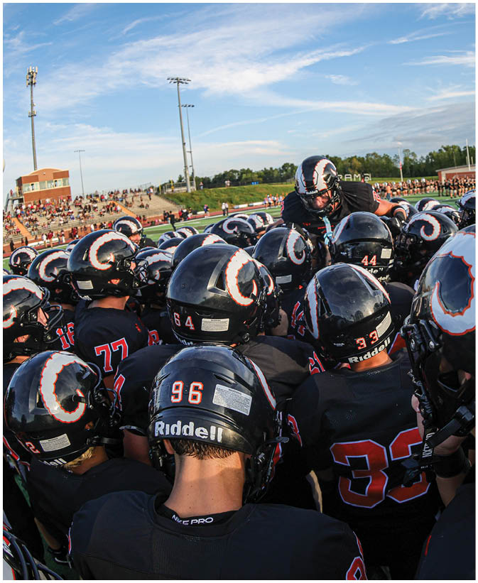 A group of football players on a field. Description generated by AI