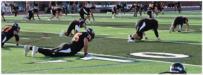 A football game is taking place on a field with players wearing blue and white uniforms. Description generated by AI
