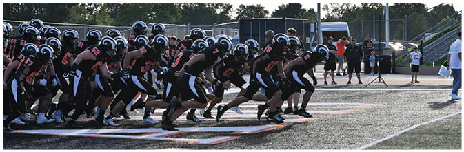 A group of football players on a field. Description generated by AI