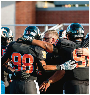 A group of football players celebrating a touchdown. Description generated by AI