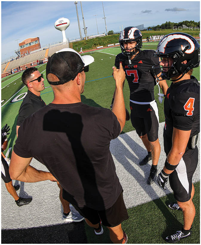 A group of football players on a field. Description generated by AI
