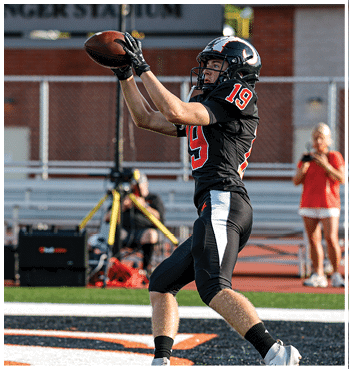 A group of football players celebrating a touchdown. Description generated by AI