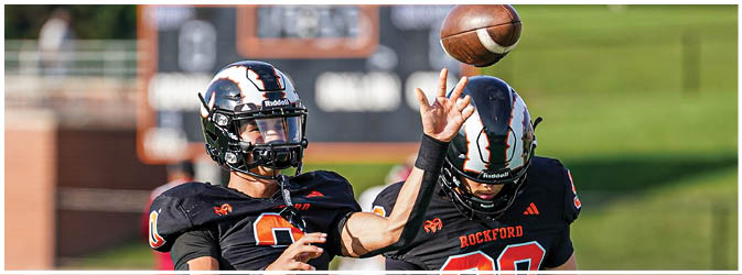 A football game is taking place on a field with players wearing blue and white uniforms. Description generated by AI