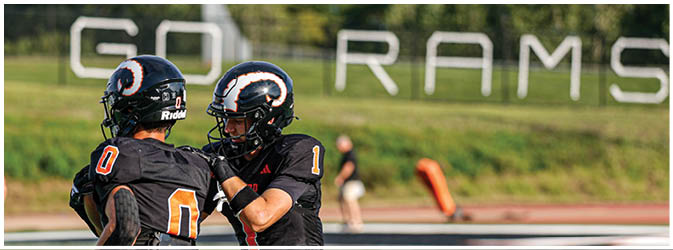 A football game is taking place on a field with players wearing blue and white uniforms. Description generated by AI