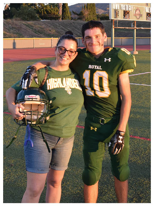 Two football players wearing black jerseys and holding hands. Description generated by AI