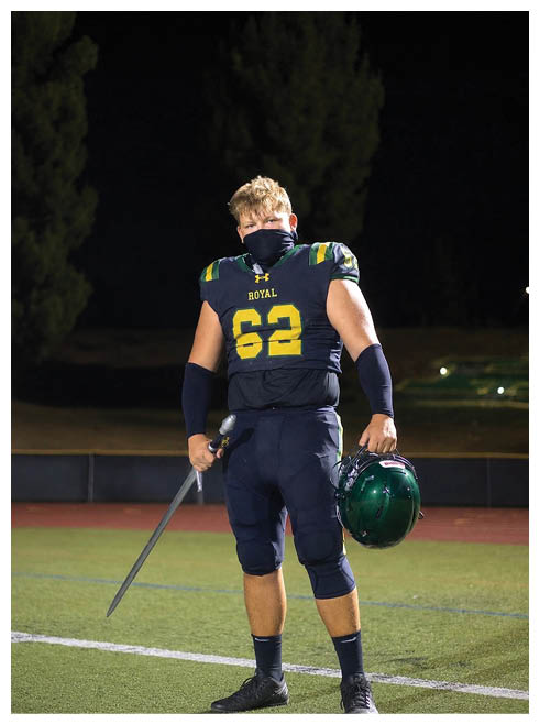 Two football players wearing black jerseys and holding hands. Description generated by AI